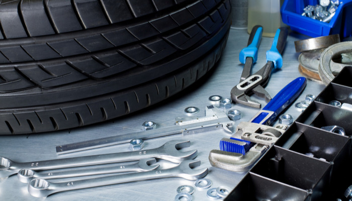 Auto repair tools on metal table with tire on the background